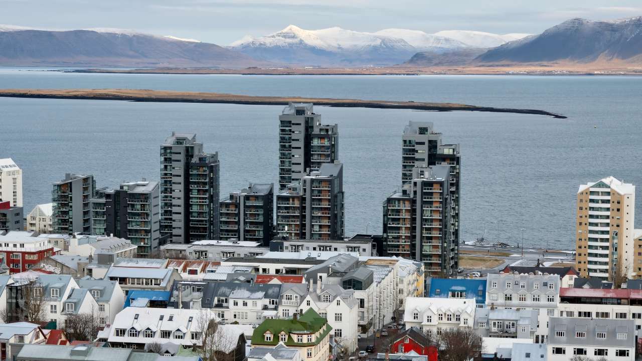 Horft yfir Reykjavík, háhýsi í forgrunni og hafið og Esjan í bakgrunni.