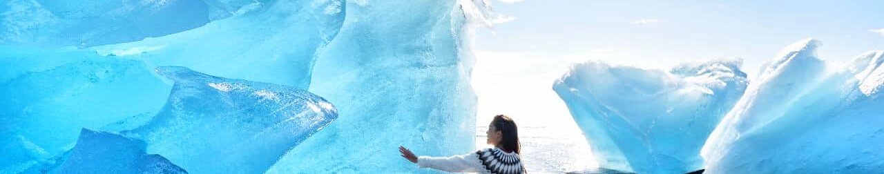 Kona snertir ísjaka á Breiðamerkursandi.